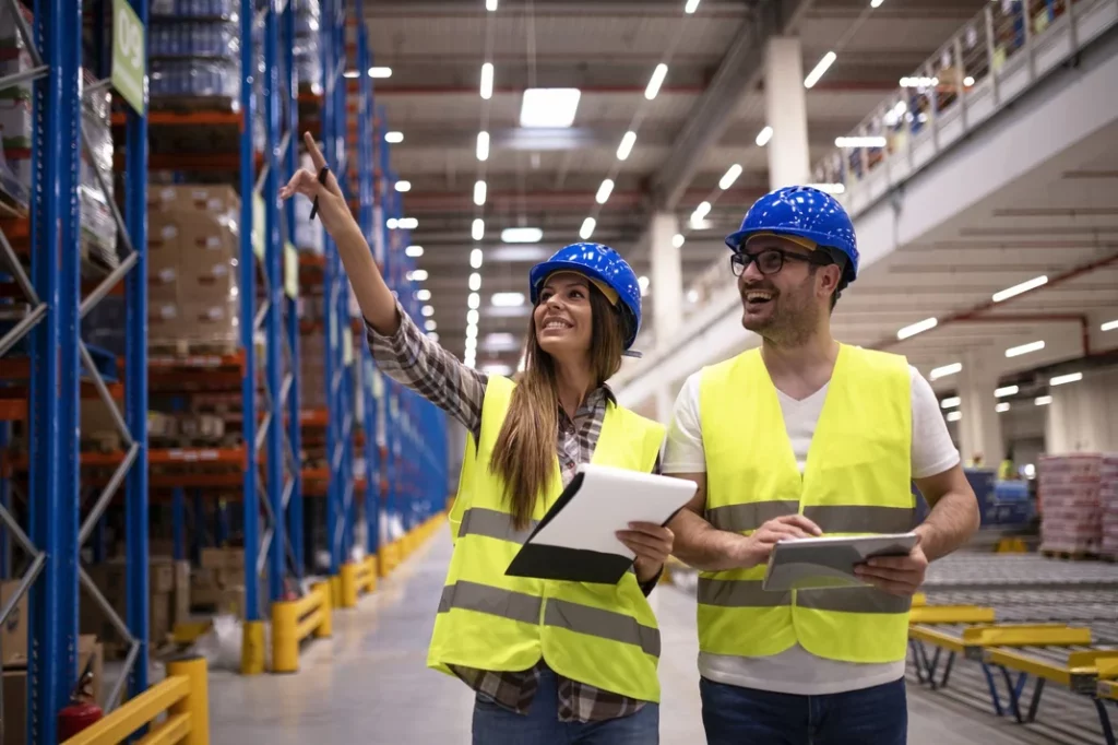 warehouse workers protective uniform walking through large distribution center organizing goods distribution