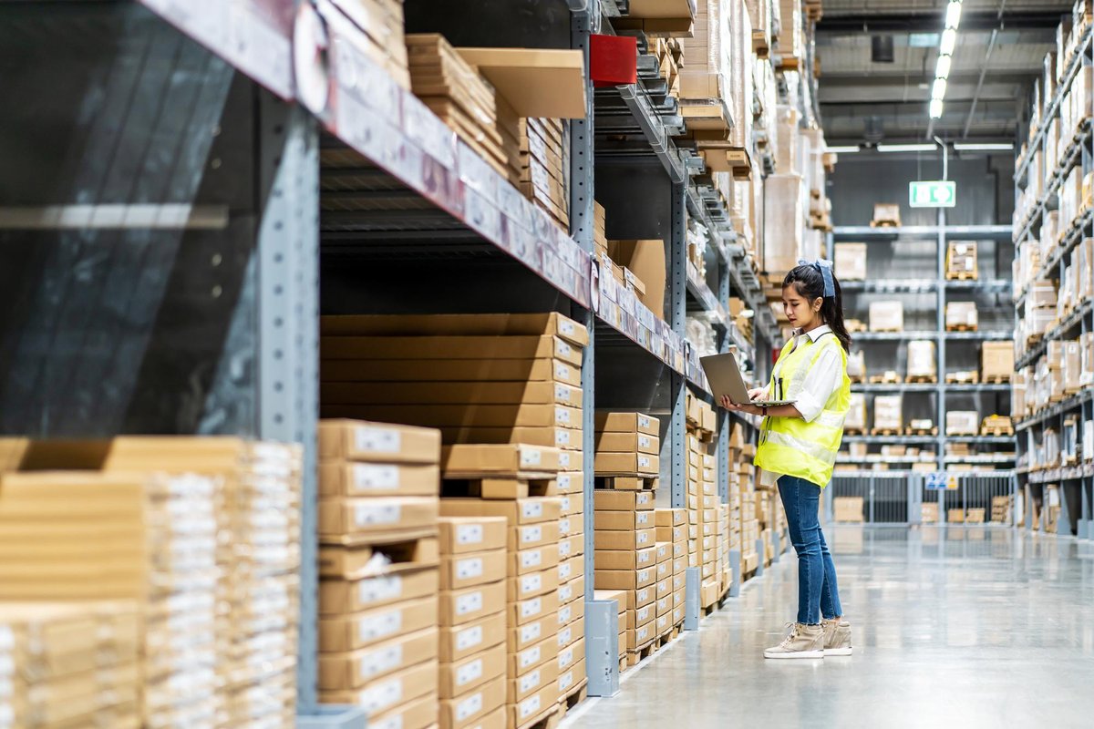 Engineer woman check stock details on tablet for checking boxes with logistics in warehouse