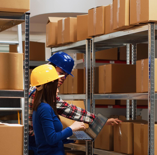 Man and woman using laptop to work on products distribution, business development