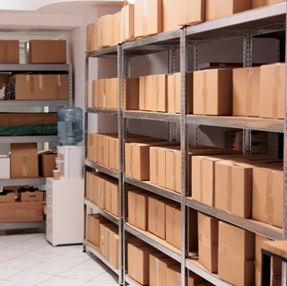 Storehouse interior with stacked cardboard boxes on tall metal racks