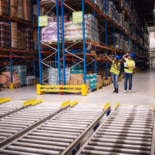 Warehouse workers checking inventory and goods distribution in large storehouse